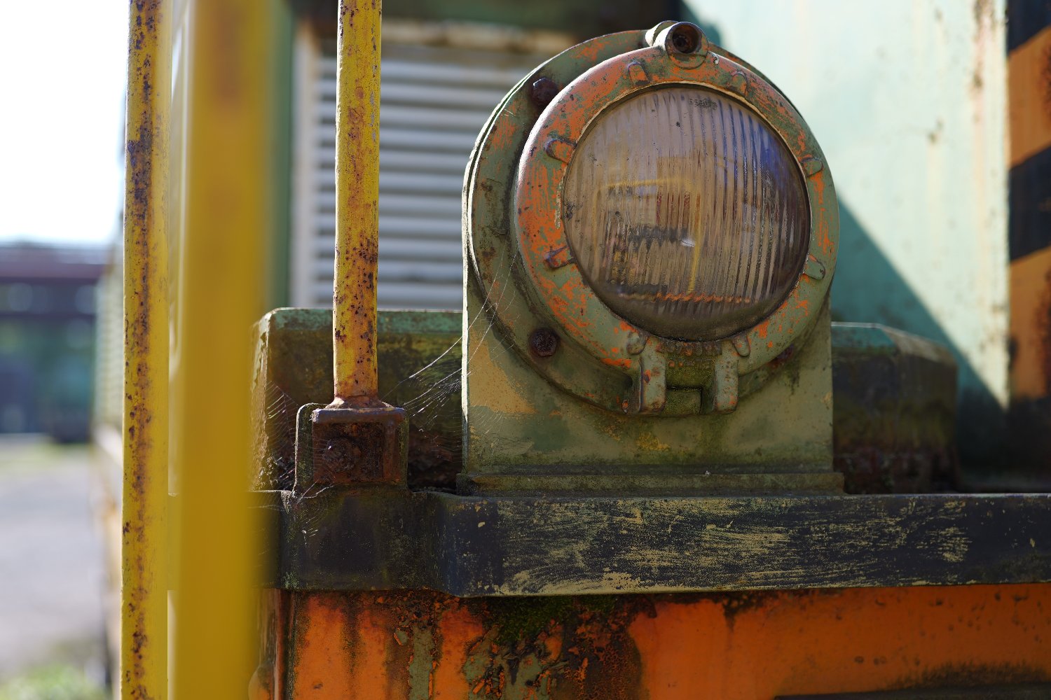 Headlight of a Train with a disturbed reflection of an industrial complex